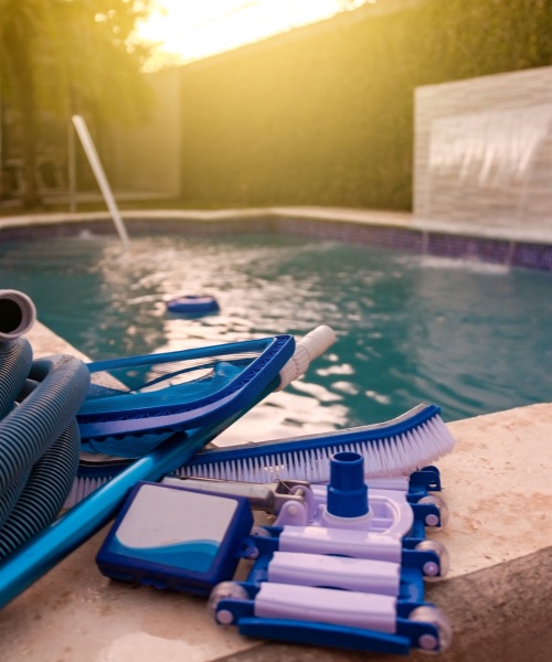 Pool-cleaning tools ready beside a residential pool